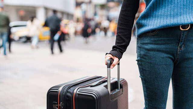 Traveler carrying suitcase luggage at outdoor destination..