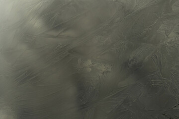 Mroźny poranek na łące. Zamarznięta powierzchnia kałuży. Połyskliwa powierzchnia lodu pokryta jest delikatnymi nierównościami tworzącymi finezyjne wzory. © boguslavus