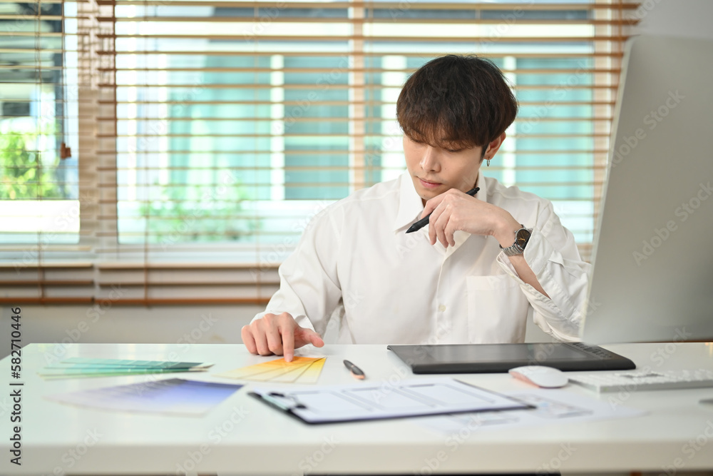 Poster image of asian man designer developing a new app design and user interface at creative office