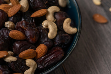 dates and nuts in a bowl on a dark background