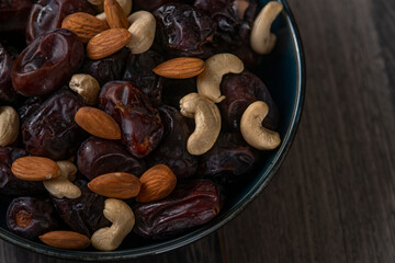 dates and nuts in a bowl on a dark background