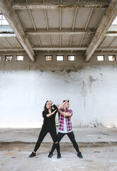 Boy and girl dancing hip-hop in old industrial building. Young couple art dance. Street urban lifestyle.