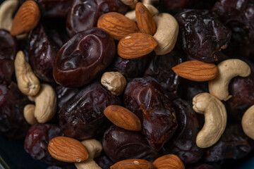 dates and nuts in a bowl on a dark background
