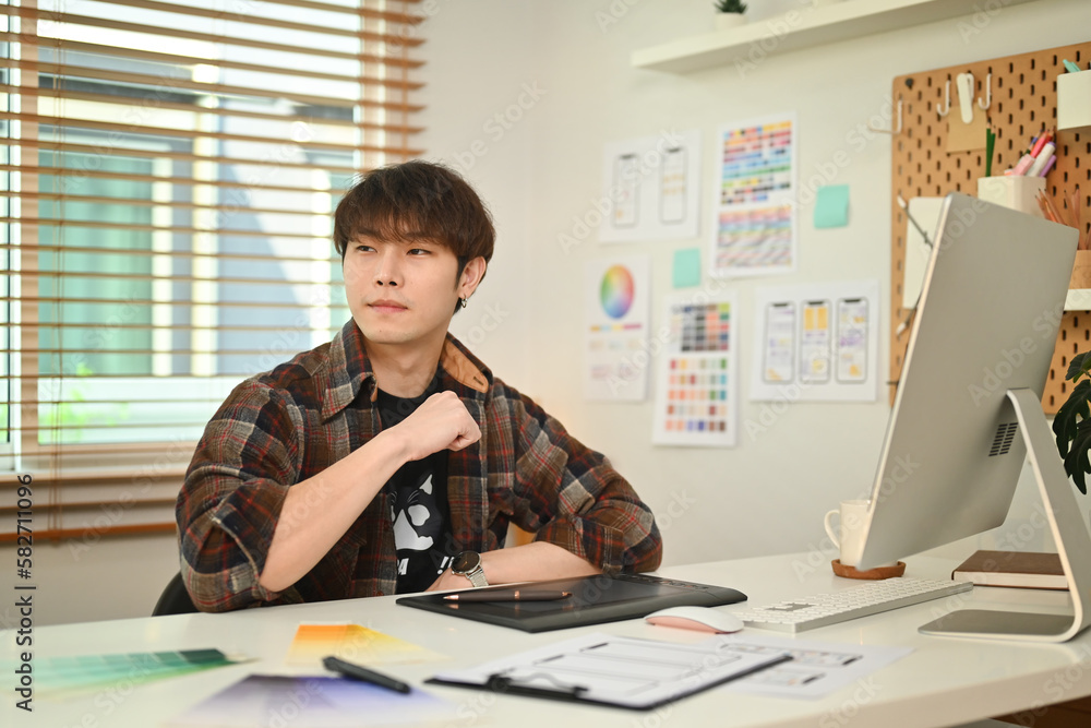 Poster shot of asian man user experience designer planning application process and working on new applicati