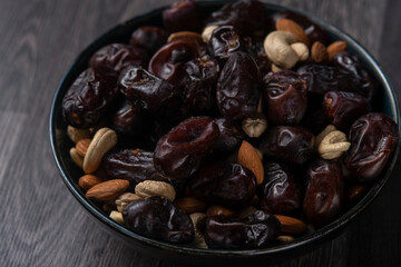 dates and nuts in a bowl on a dark background