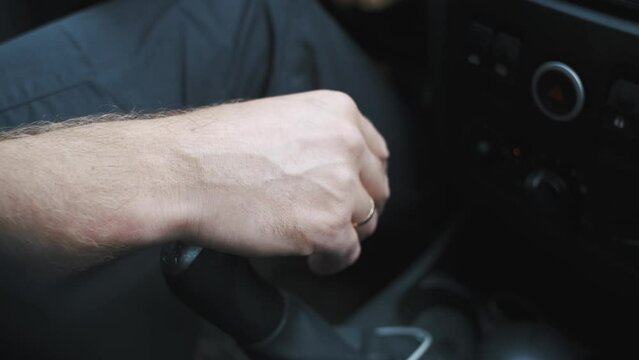 close-up of a man's hand on the gear lever of a car