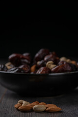 dates and nuts in a bowl on a dark background