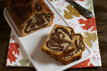 Bizcocho marmolado de vainilla y chocolate sobre tabla blanca de cerámica