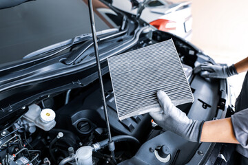 Auto mechanic checking, cleaning and replacing car air filter. Concept of car care service...