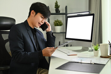 Shot of marketing sales manager making offer selling to client, talking on mobile phone at his workstation