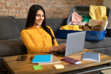 Special travel offer. Excited spanish lady booking tourist trip online, planning vacation with...