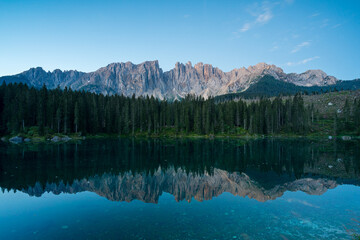 Latemar Gruppe, Felsmassiv, in den Dolomiten in Südtirol im Morgenlicht mit Spiegelung in Bergsee, Karer See.