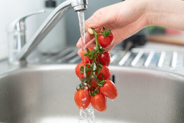 washing tomato in a kitchen sink