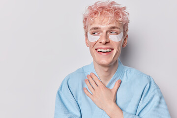 Facial beauty skincare. Positive pink haired woman smiles pleasantly applies skin care patches...