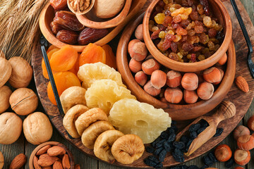 Tu Bishvat celebration concept. Mix of dry fruits and nuts almonds, hazelnuts, walnuts, apricots, prunes, cherries, raisins, dates, apples, figs over wooden table. Jewish holiday, new year of trees.