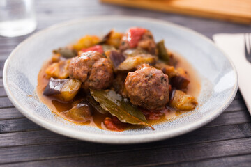 cooked meatballs with stewed eggplant in bowl