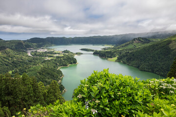 Lagoa Azul and Lagoa Verde in Sao Miguel, Azores / The island of Sao Miguel, the volcanic lakes Lagoa Azul, Lagoa Verde and the village of Sete Cidades lie in a vast Caldeira, Azores, Portugal. - 582721888