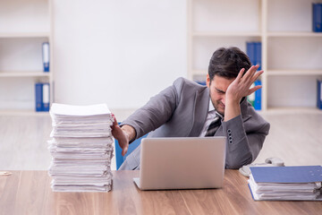 Young male employee and too much work in the office