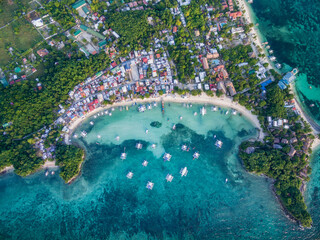 Sunny Day in Malapascua Island in Visayan Sea, One of Cebu Island. Sea water and Boats. Bounty Beach with Local Architecture