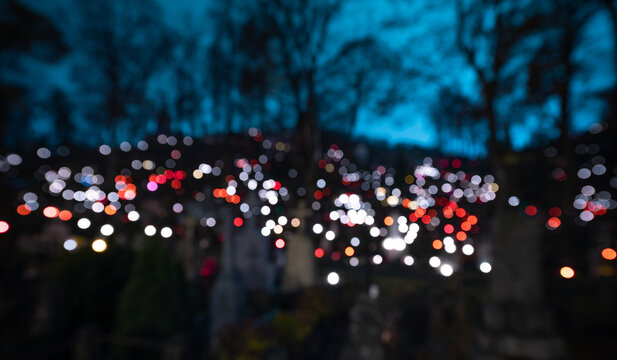 Catholic Cemetery Rasos in Vilnius, Lithuania. All Saints' Day November 1st. Blurry Candles Light Background. - Powered by Adobe