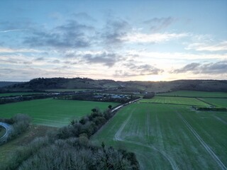 Sunset behind chalk hills, final light over the farm land and motorway