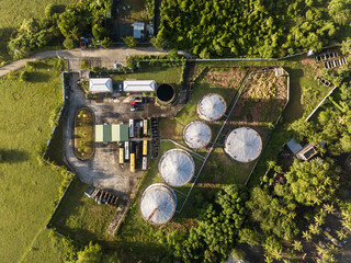 Top aerial view of a small oil terminal with several tanks in a rural area in the Philippines.