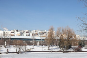 Obraz premium Alley in the park with melting snow, puddles and ice in the spring, underground metro. Butovo, Moscow. thawed patches. month of March 2023.