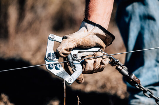 Hand using strainer tool for fencing