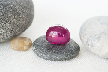 Natural red ruby cabochon drop shaped gestone loose polished translucent setting lying on a gray...