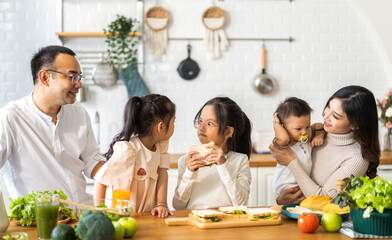 Portrait of enjoy happy love asian family father and mother with little asian girl daughter child having fun help cook food healthy eat with fresh vegetable salad and sandwich ingredient in kitchen