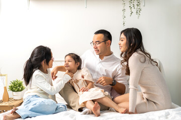 Fototapeta premium Portrait of enjoy happy love asian family father and mother holding hug cute little asian girl child smiling play and having fun moments good time in at home