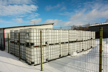  plastic cubic water container protected by a metal grid