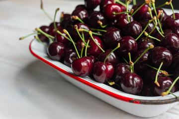 fresh juicy cherries in an old enamelware dish