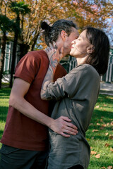 Naklejka premium Candid lifestyle portrait of two happy young people hugging each other in autumn park.