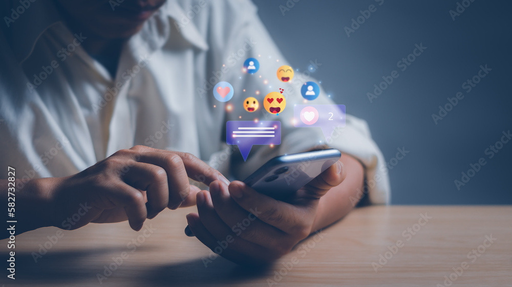 Aufkleber man's hand using a smartphone to play or use social media while working remotely at home through the