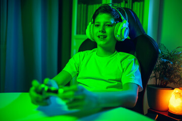 Little boy with gamepad playing video game at home