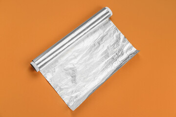 Aluminium foil roll on orange background