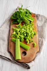 Raw Green Organic Celery on a rustic wooden board, low angle view.