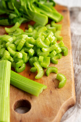 Raw Green Organic Celery on a rustic wooden board, low angle view. Close-up.