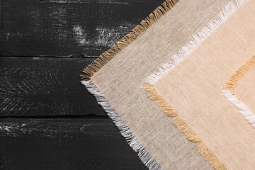 Set of clean napkins on dark wooden background, closeup