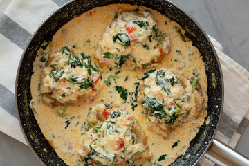 Homemade Creamy Tuscan Chicken with Spinach in a Pan, top view. From above, overhead, flat lay.