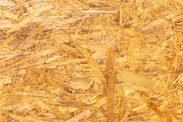 OSB board texture. Brown wooden background. Simple pressed chipboard pattern. Chip board background. Brown wood texture.