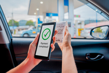 Woman using contactless payment by mobile phone with QR code at car filling station
