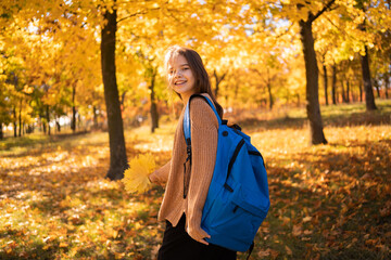 Back to school. Girl student with big backpack walk in autumn park. Education, future of children. Happy pupils walk themselves