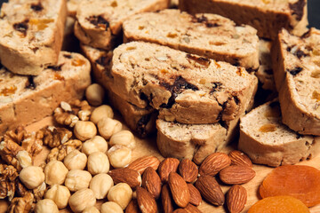 Delicious biscotti cookies, dried apricots and nuts on board, closeup