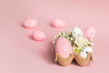 Painted pink and white easter eggs in tray with flowers. Colorful decorations, Easter gift. Pink background. Copy space. Minimalism. Happy Easter concept
