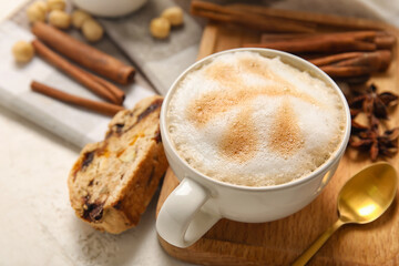 Board with cup of coffee and delicious biscotti cookie on white grunge background, closeup