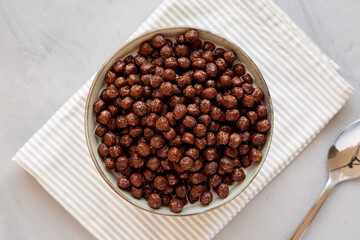 Chocolate Puff Cereal with Milk in a Bowl, top view. Flat lay, overhead, from above.