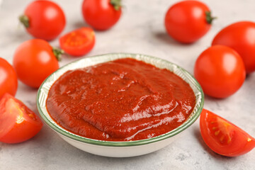 Bowl of tasty tomato paste on grey grunge background