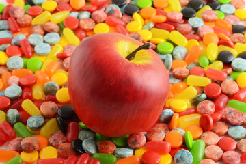 apple on pile of assorted candy background